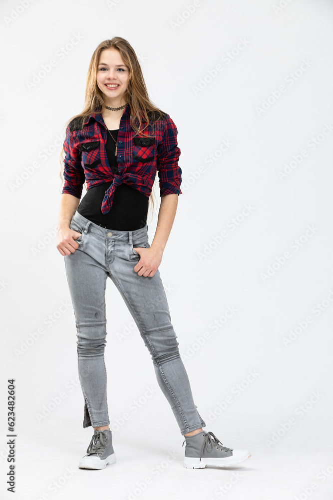 A confident girl stands with her hands tucked in the pockets of her pants. A confident girl stands with her hands tucked in the pockets of her pants.