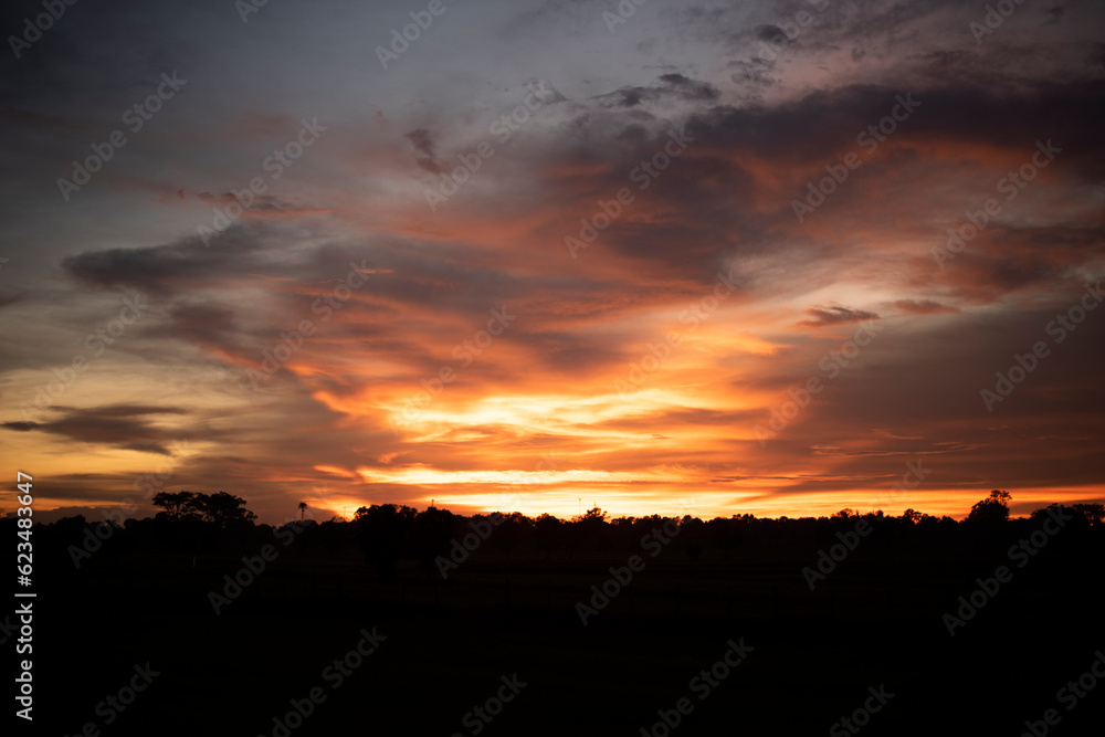 Glowing gold, orange-red, cloudy sky at sunset. Wallpaper concept.