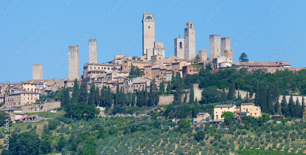 San Gimignano village, Italy: green countryside, blue sky, hill panorama with town and towers