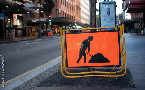 Photography roadwork ahead sign located on street side in tne city, driving carefullly atten