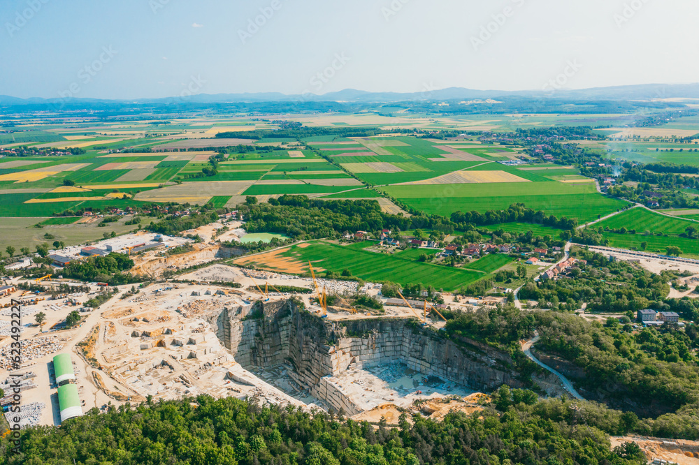 Aerial view of a large open pit mine in a rural landscape