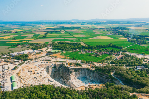 Aerial view of a large open pit mine in a rural landscape