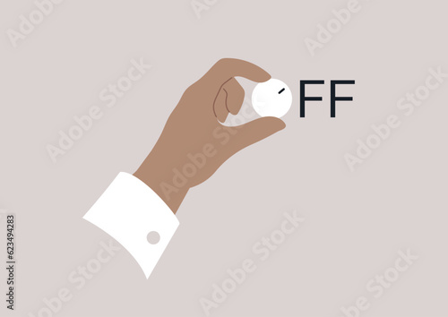 A hand turning off a volume tuner on a control panel