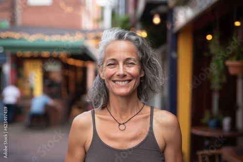 Headshot portrait photography of a grinning mature woman wearing a daring bikini against a lively pub background. With generative AI technology © Markus Schröder