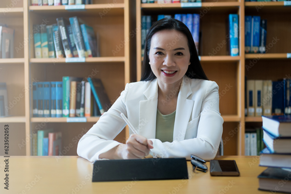 Female university lecturer working in library Female university lecturer working in library