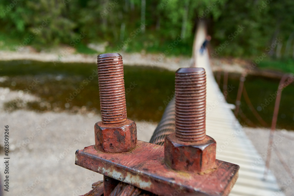 Old Rusty Metal Bolt, suspension bridge in the Oleniye Ruchiye Nature Park in the Sverdlovsk region Old Rusty Metal Bolt, suspension bridge in the Oleniye Ruchiye Nature Park in the Sverdlovsk region