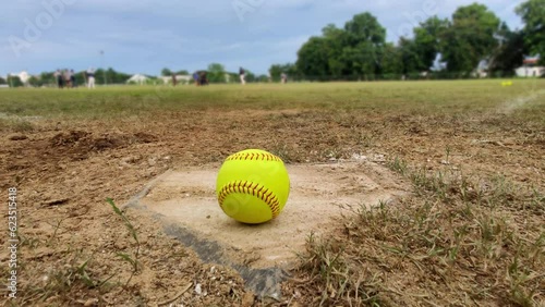 Green softball ball on homepage, with sport athlete blurred background. photo