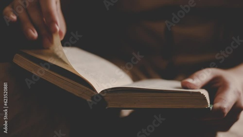 a girl in a vintage dress reads an ancient book at home. female hands turning pages in a book. close up. Woman reading book.