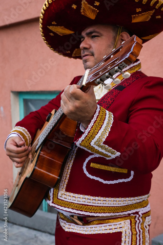 Mexican musician mariachi plays the guitar on a city street.