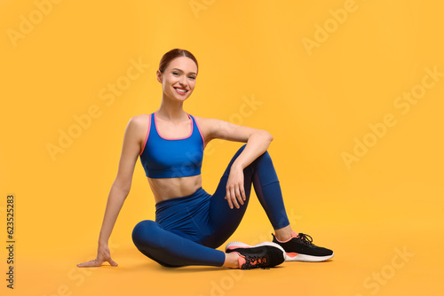 Young woman wearing sportswear on yellow background © New Africa