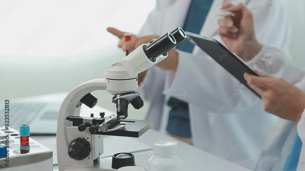 Health care researchers working in life science laboratory. Young female research scientist and senior male supervisor preparing and analyzing microscope slides in research lab. Health care researchers working in life science laboratory. Young female research scientist and senior male supervisor preparing and analyzing microscope slides in research lab.
