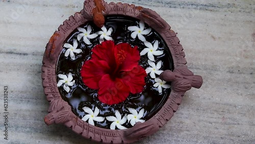 spiritual holy water with hibiscus flower kept for birds at home entrance from different angle photo