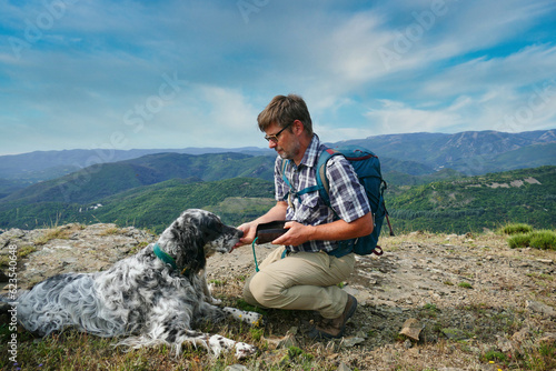 Canvas Print man and his dog resting during a hike in the mountains