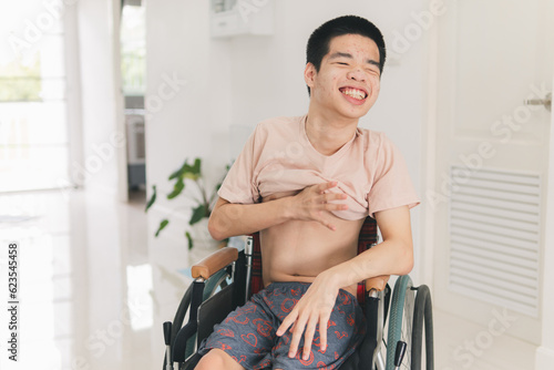 Asian young man Practicing wearing short-sleeved T-shirts by himself, Practice muscle development,occupational therapy, Skills needed in everyday life, Confidence building and self-help concept.