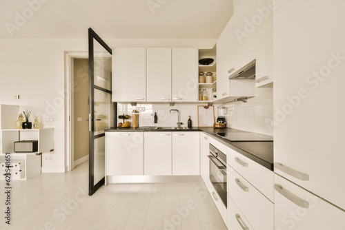 a modern kitchen with white cabinets and black counter tops on the island in this small space is very well organized