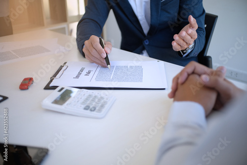 Sales manager giving advice application form document, considering mortgage loan offer for car and house insurance.