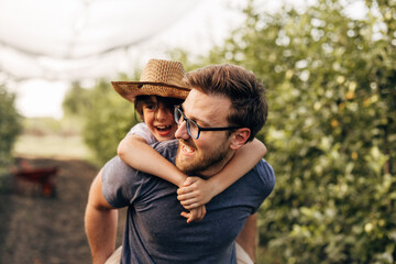 Closeup view of a cute boy on his fathers back in nature.