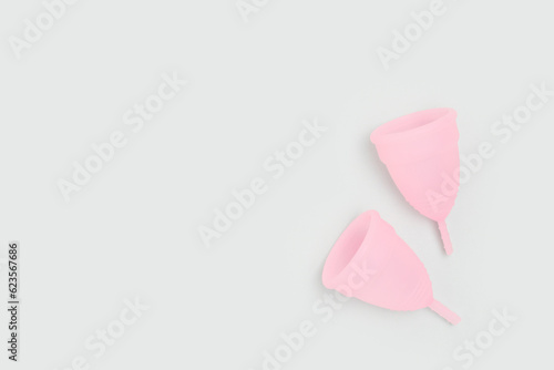 Pink menstrual cups on a blue background. Zero waste period concept with place for text. photo