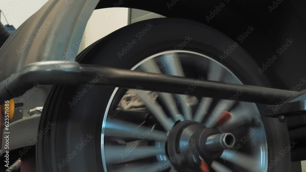 Wheel balancing. Tire fitting. Car service. close-up. The wheel is spinning for balancing in a tire shop. Wheel balancing. Tire fitting. Car service. close-up. The wheel is spinning for balancing in a tire shop.