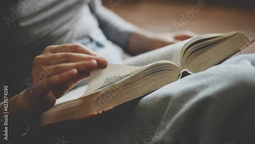 girl sitting on the floor and reading a book at home. Student preparing for the exam and reading literature. hobbies, lifestyle and pre-leisure