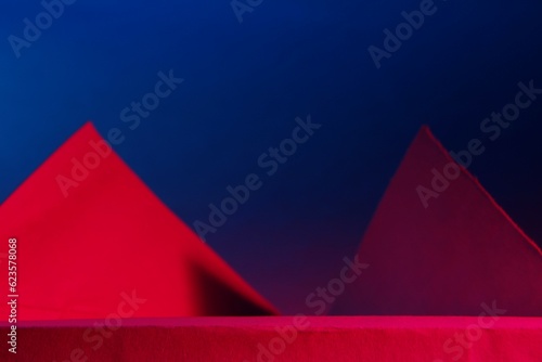 Pared con triángulos de cajas de cartón recicladas para regalo, con luz roja produce un contraste de iluminación con una sombra en su base, formando un original diseño abstracto con fondo azul
