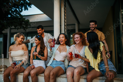 Multiethnic family and friends make a reunion at house balcony, toasting and having fun