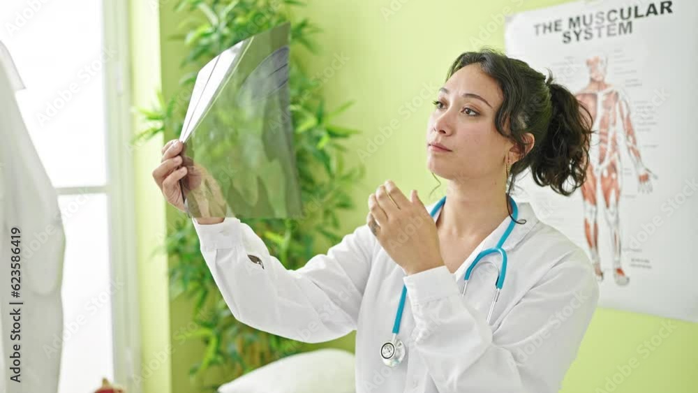 Young beautiful hispanic woman doctor looking xray thinking at clinic Young beautiful hispanic woman doctor looking xray thinking at clinic
