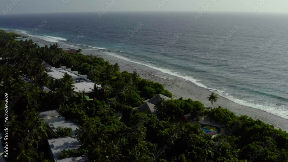 Aerial view of luxury villas over water on blue lagoon, white sandy beach. An island with bungalows over water standing in rows in the Maldives. Aerial view of luxury villas over water on blue lagoon, white sandy beach. An island with bungalows over water standing in rows in the Maldives.