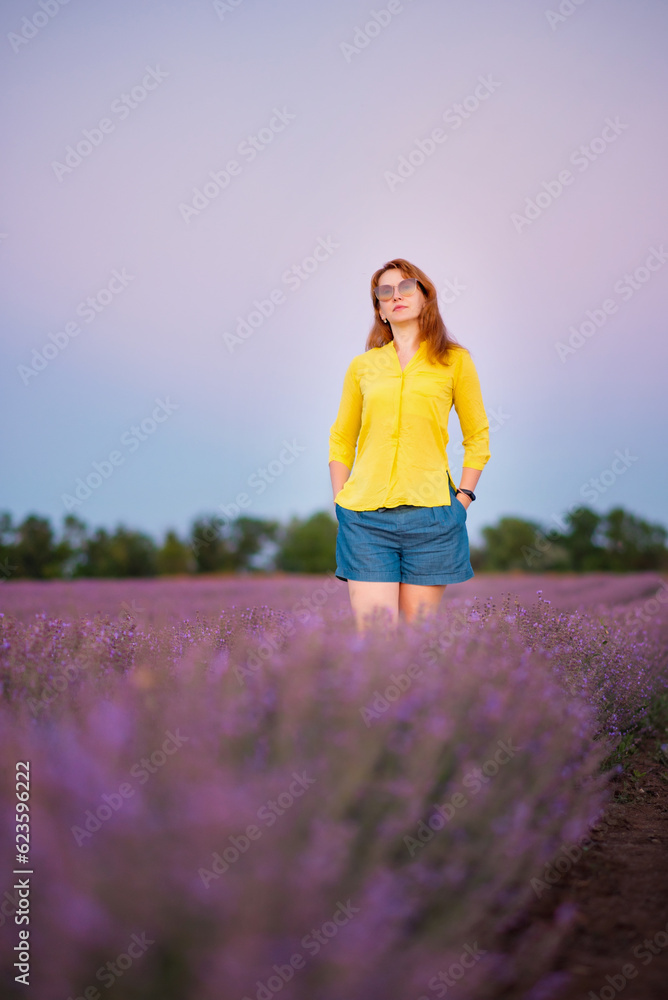 lavender field, a young woman in a yellow blouse and sunglasses walks in the field and smiles happily, summer july, lavender cultivation lavender field, a young woman in a yellow blouse and sunglasses walks in the field and smiles happily, summer july, lavender cultivation