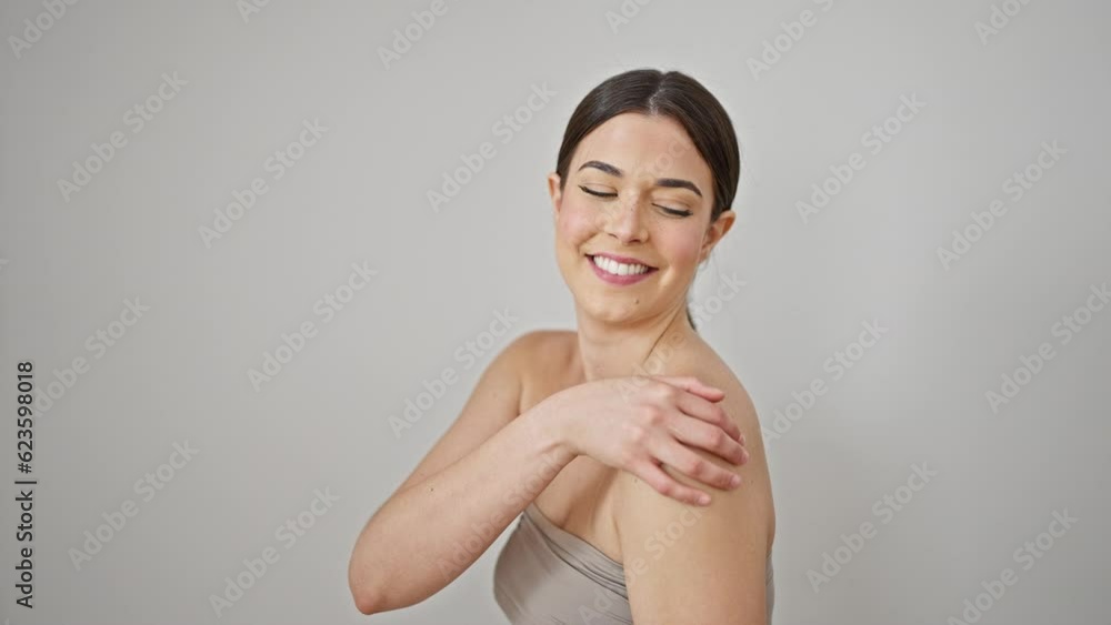 Young beautiful hispanic woman smiling confident touching shoulder over isolated white background