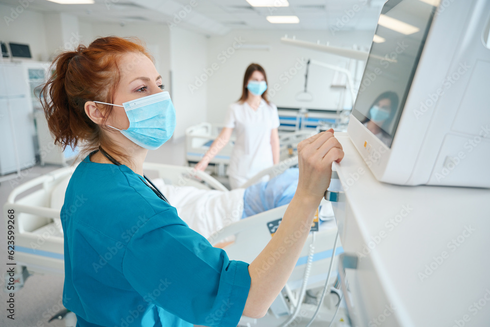 Physicians assessing condition of patient well-being in the intensive care unit