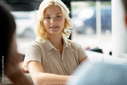 Free Download Portrait of smiling smart school girl sitting in classroom. Teenager studying in modern library. Education concept - GFXLoad