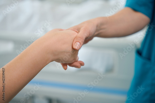 Female medic shaking hands with her colleague in hospital