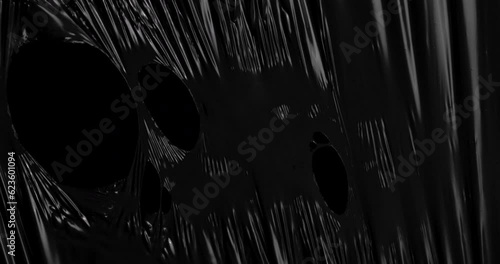 Unleash your creativity as stretched plastic film weaves its intricate patterns against a backdrop of infinite blackness, its texture reminiscent of the rhythmic folds.