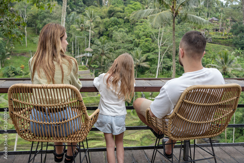 Family with littke kid travel around Bali island. Family holiday enjoying tropical island with paddy rice field in the background. Family summer vacation in Bali, Indonesia. photo