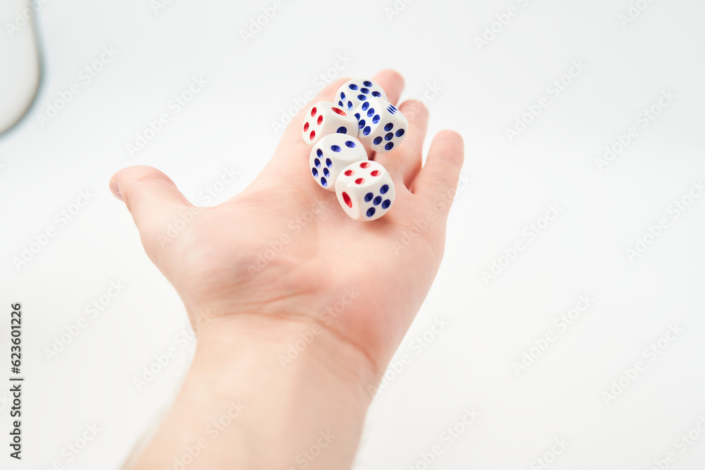 Male hand throwing white dice in the air on white background. Game with dice, Hazard, Cho-Han Bakuchi, Under-Over 7, Mexico, Shut the Box. Gambling luck concept: bet, risk, have luck, win. lucky