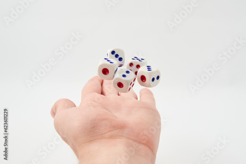 Male hand throwing white dice in the air on white background. Game with dice, Hazard, Cho-Han Bakuchi, Under-Over 7, Mexico, Shut the Box. Gambling luck concept: bet, risk, have luck, win. lucky photo