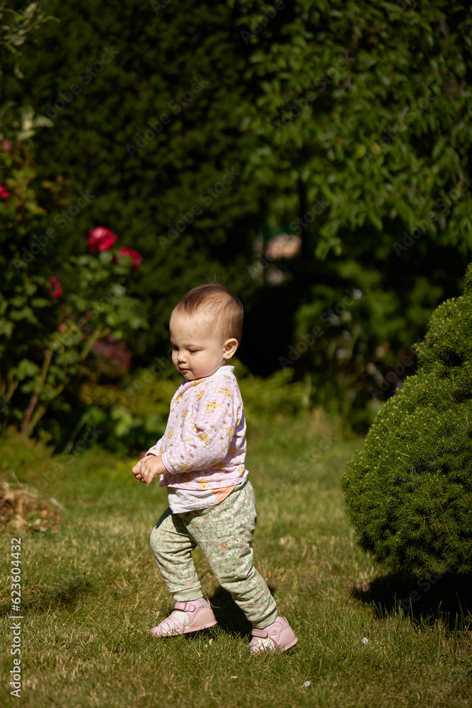 little baby girl playing in the garden in summer day little baby girl playing in the garden in summer day