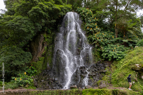 Waterfall in the Botanical Garden of Ribeira do Guilherme in Nordeste with tourists  Sao Miguel island in the Azores.