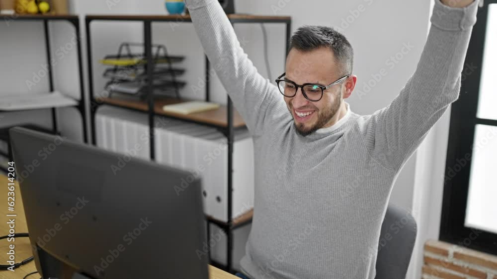 Hispanic man business worker using computer celebrating at office Hispanic man business worker using computer celebrating at office