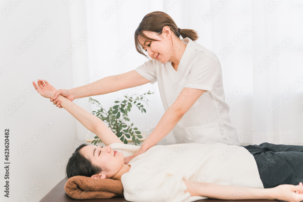 患者の腕・肩をマッサージする整体師の女性(理学療法士・作業療法士)
患者の腕・肩をマッサージする整体師の女性(理学療法士・作業療法士)