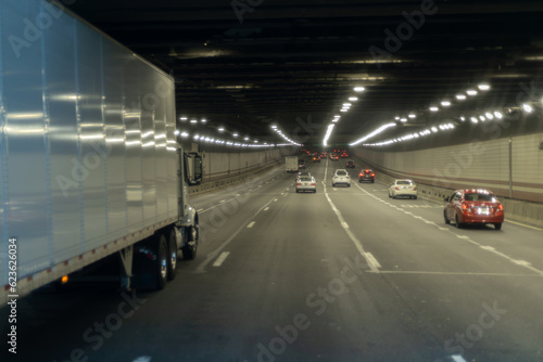 A car that is driving down a tunnel with a truck on the back.