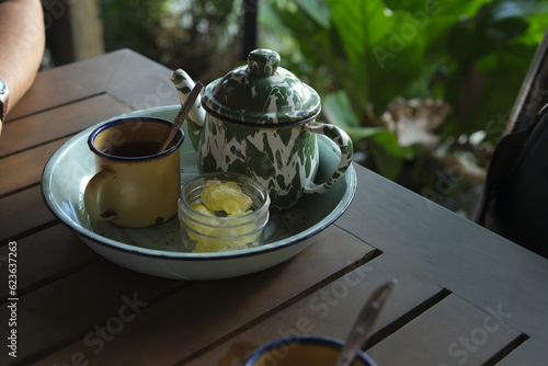 Poci Tea, Teh Poci or tea in enmamel pot oj the table with ature background. Javanese traditional drink photo