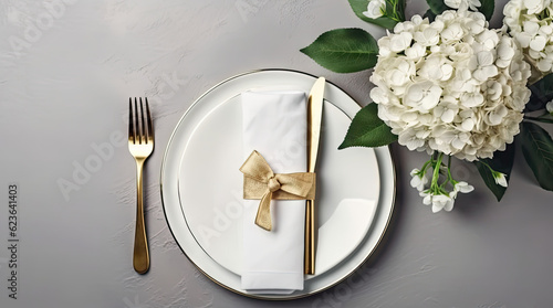 Festive wedding, birthday table setting with golden cutlery, silk ribbon, eucalyptus branches, hydrangea and white roses flowers. Blank card mockup. Restaurant menu concept. Flat lay, top view