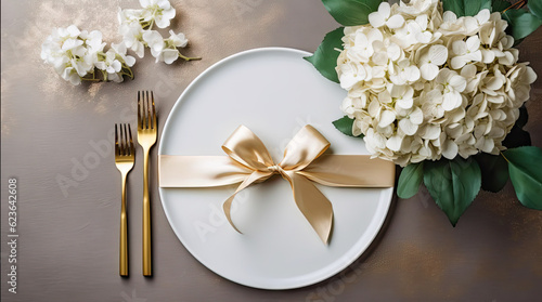 Festive wedding, birthday table setting with golden cutlery, silk ribbon, eucalyptus branches, hydrangea and white roses flowers. Blank card mockup. Restaurant menu concept. Flat lay, top view © Joel Valdez