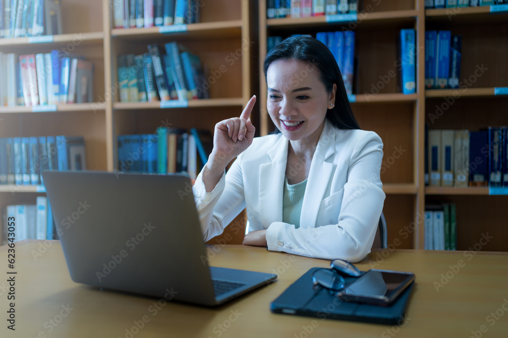 University teacher giving online consulting student via laptop in library University teacher giving online consulting student via laptop in library