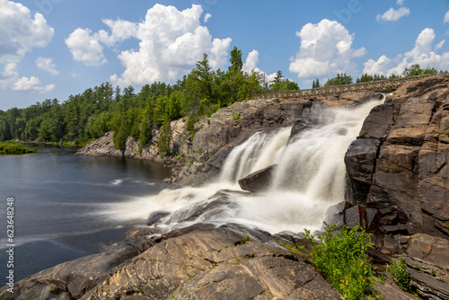 High Falls in the Muskoka town of Bracebridge, Ontario flows into the lake below on a bright sunny day.