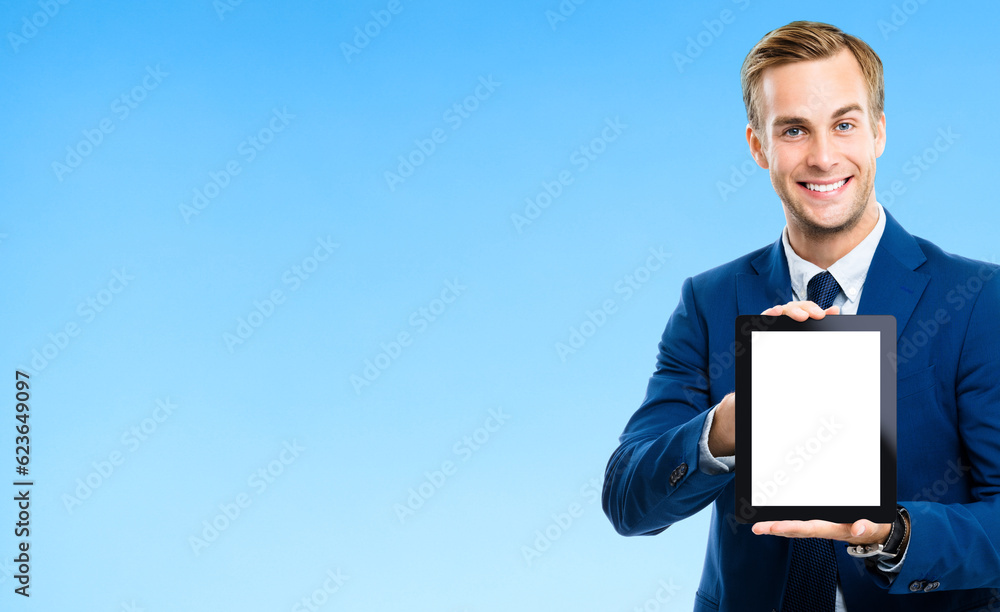 Portrait image of businessman showing blank tablet pc, with copy space area for some text, advertising or slogan, on blue background. Smiling man at business studio concept. Portrait image of businessman showing blank tablet pc, with copy space area for some text, advertising or slogan, on blue background. Smiling man at business studio concept.