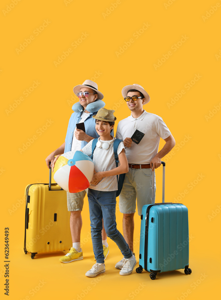 Happy little boy with his dad and grandfather travelling on yellow background Happy little boy with his dad and grandfather travelling on yellow background