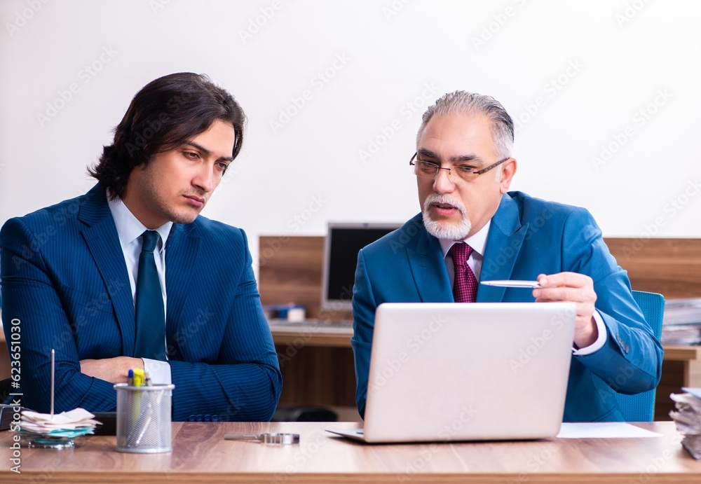 Young and old employees working together in the office Young and old employees working together in the office